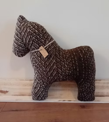 Geweven decoratief paard in bruine en zwarte kleuren met een etiket.